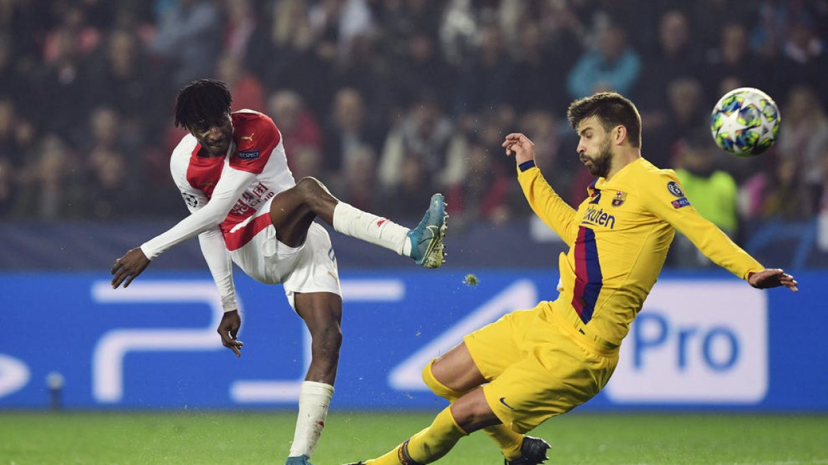 Peter Olayinka dispara a porta davant del blaugrana Gerard Piqué.