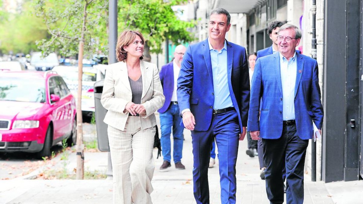 Sánchez es dirigeix a una de les reunions d’ahir flanquejat per Dolores Delgado i Fernando Martínez.