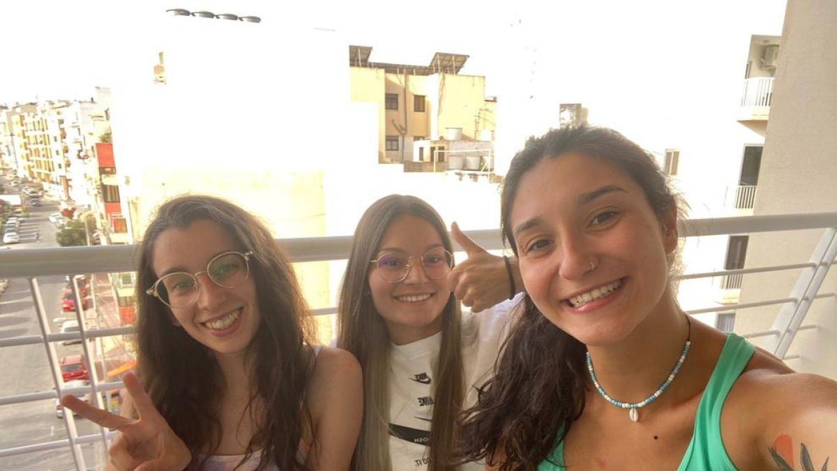 La Neus, l’Anna i la Clàudia, al balcó de l’habitació de l’hotel de Malta en la qual estan confinades.