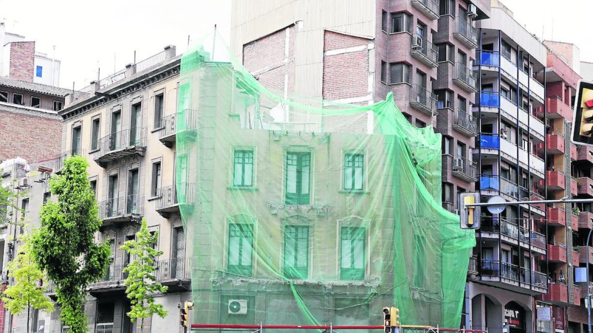 Imatge de la façana, que està tapada, sense els pisos superiors.