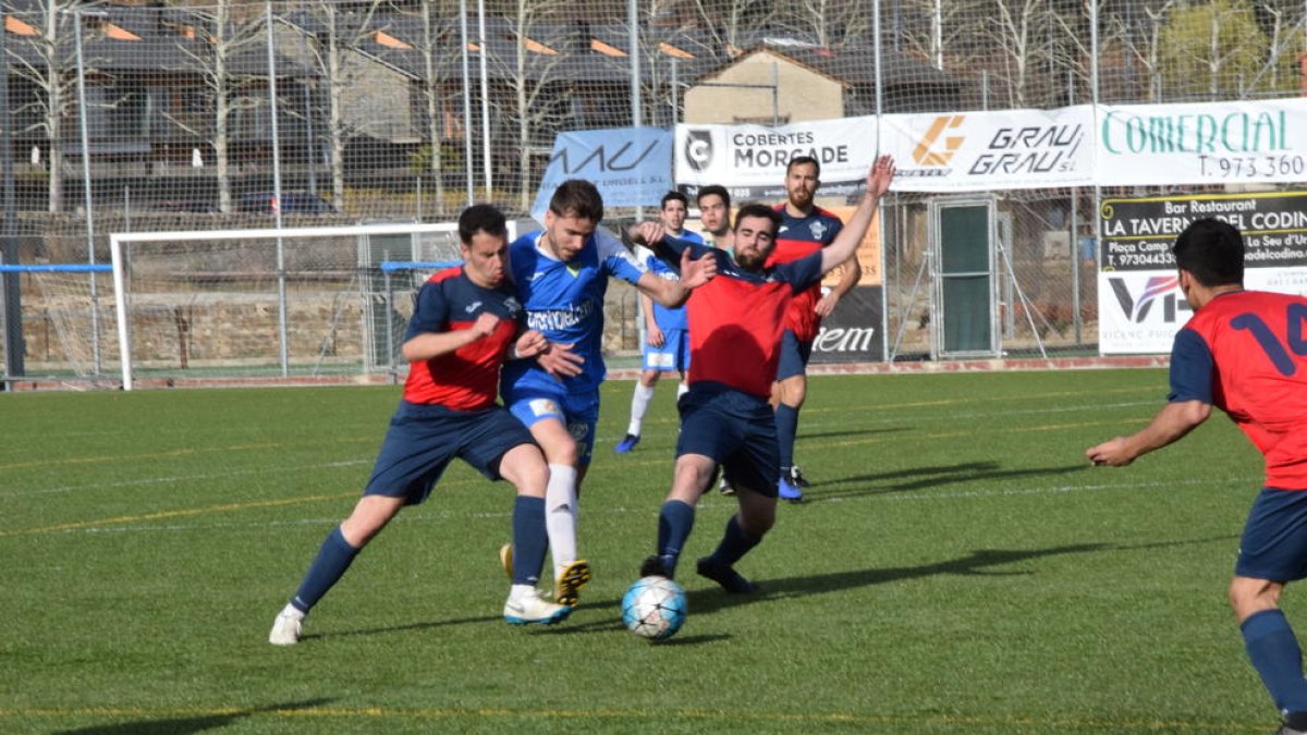 Dos jugadores del Ivars intentan quitar la posesión del balón a un jugador de La Seu.
