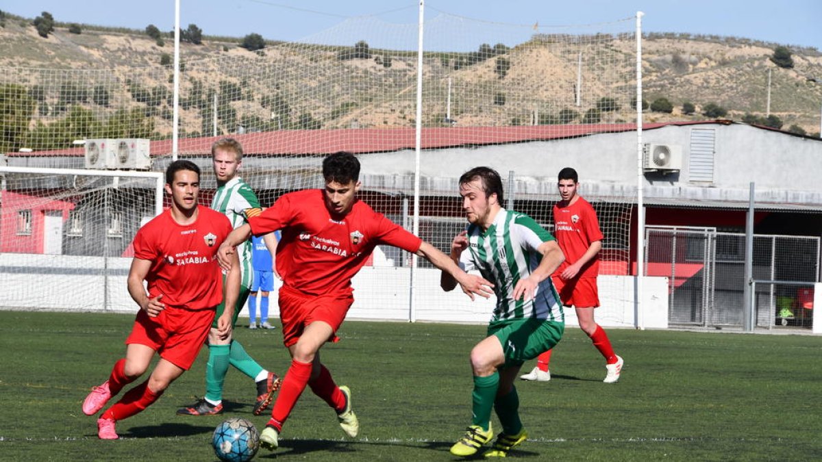 Un jugador del Alpicat B conduce el balón ante la presión de un rival.