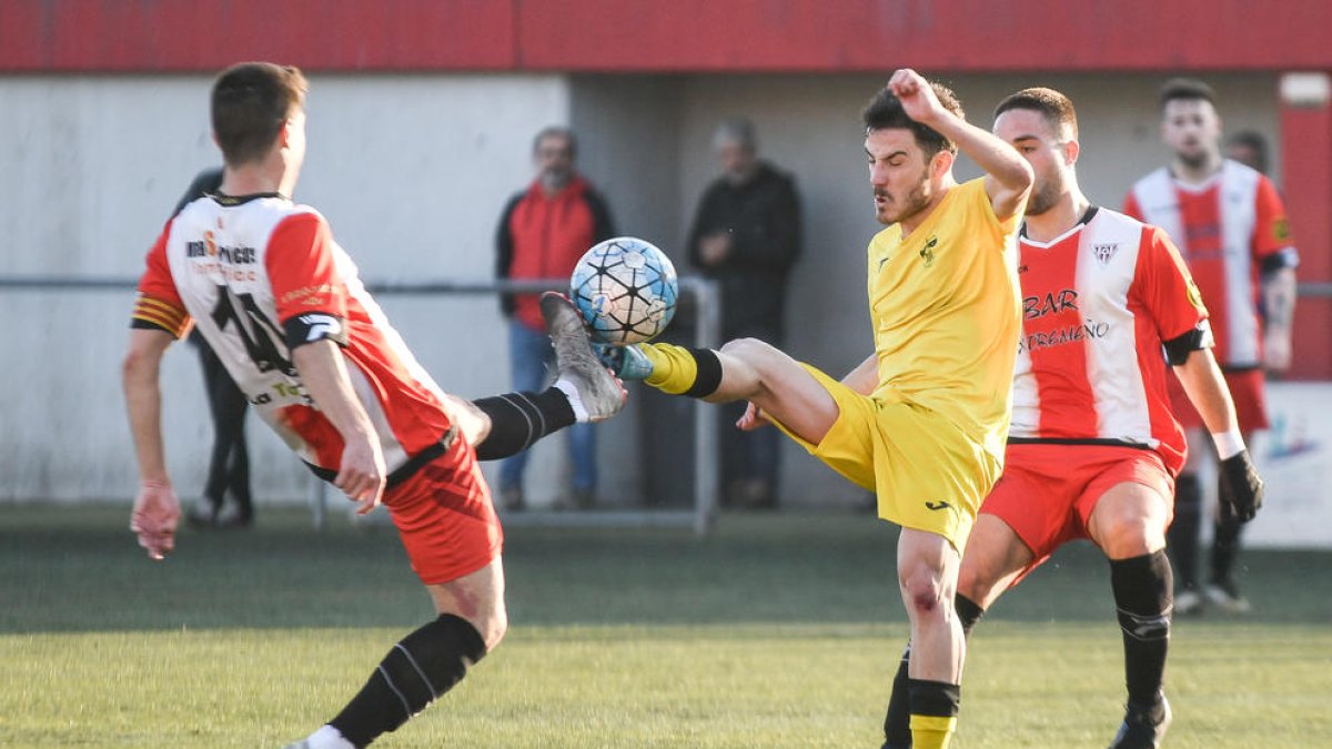 Un jugador del Almacelles pugna con un adversario por el control de un balón dividido.