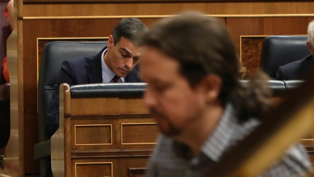 El líder de Unidas Podemos, Pablo Iglesias, pasa ante el presidente del Gobierno en funciones, Pedro Sánchez.