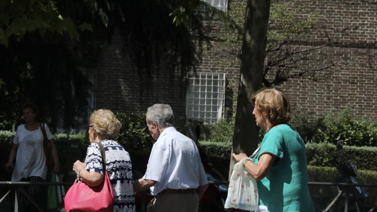 Imatge de tres pensionistes que passegen pel carrer aprofitant el bon temps.