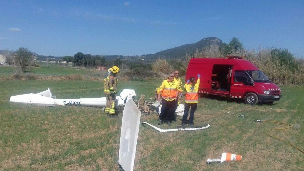 Bomberos, con los restos de la avioneta.