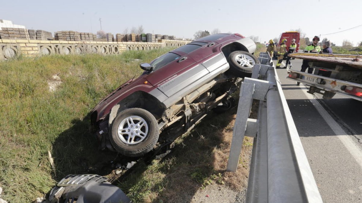 Vista del vehículo accidentado ayer al mediodía tras sufrir una espectacular salida de vía en la N-240 en Almacelles.