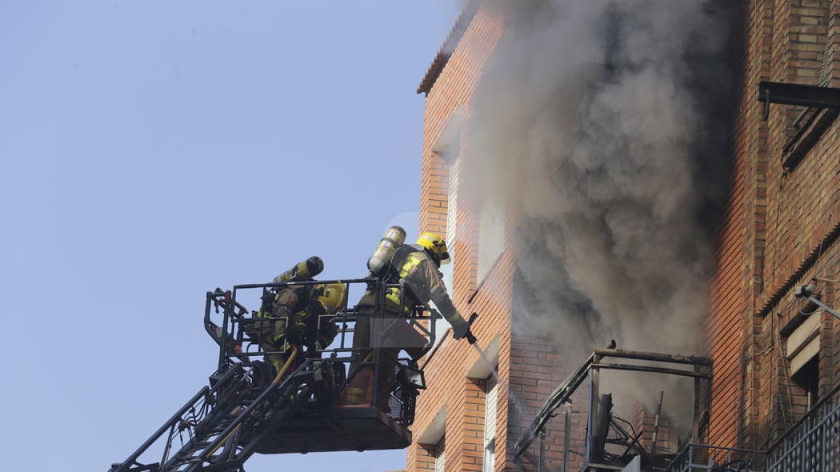 Bombers trabajan en un incendio en un piso.