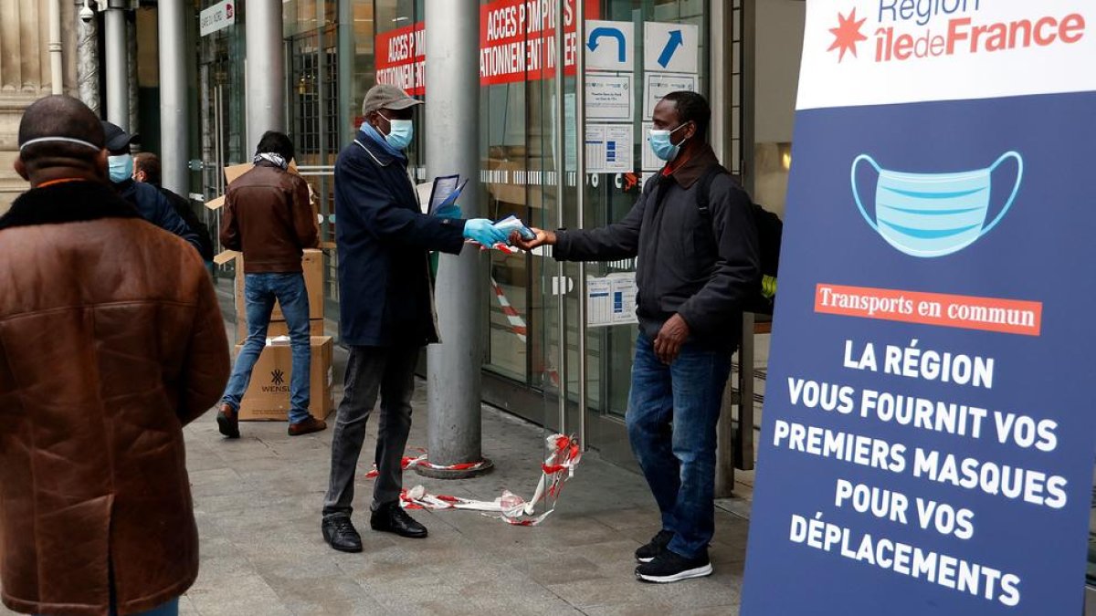 Un voluntario reparte mascarillas en una estación de París.