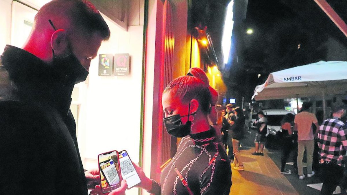 Una jove mostra el certificat en un local de Lleida.