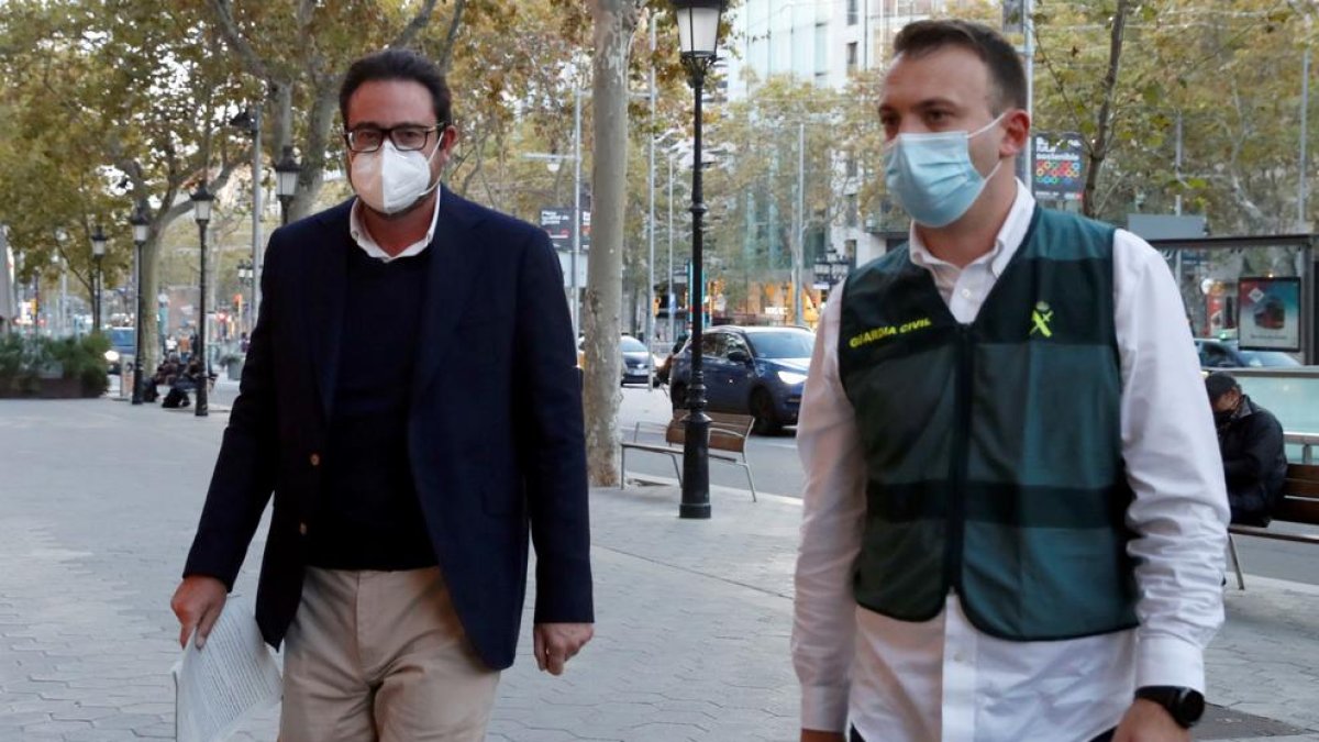 Agentes de la Guardia Civil custodian al exalto cargo de CDC David Madí (izquierda) tras ser detenido