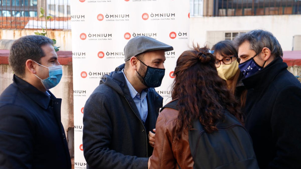 Marcel Mauri conversa con otras personas a las puertas de Òmnium.