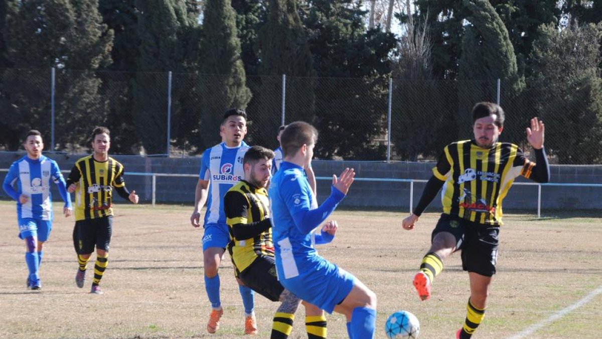 Jugadors dels dos conjunts disputen una pilota dividida en una acció del partit.