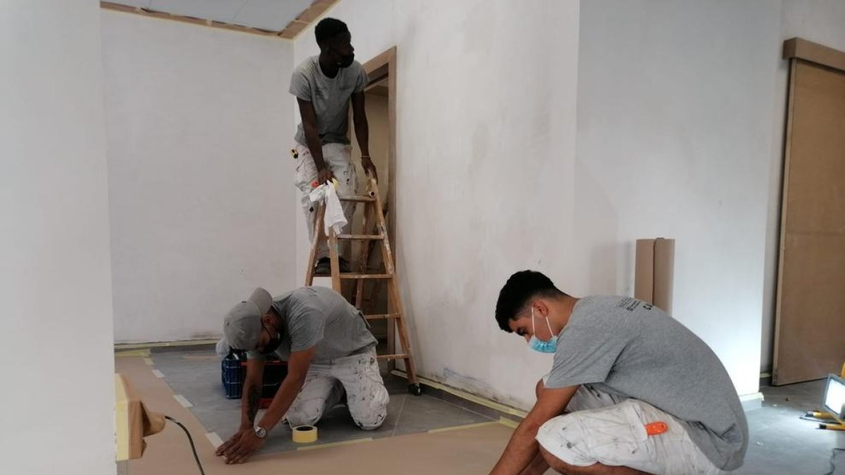 Tres de los jóvenes que participan en el taller de pintura de la Casa d’Oficis, ayer en el local de Tallada.