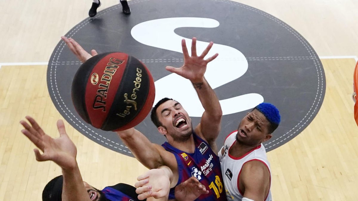 Brandon Davies y Pierre Oriola pugnan por un rebote con dos jugadores del Burgos.