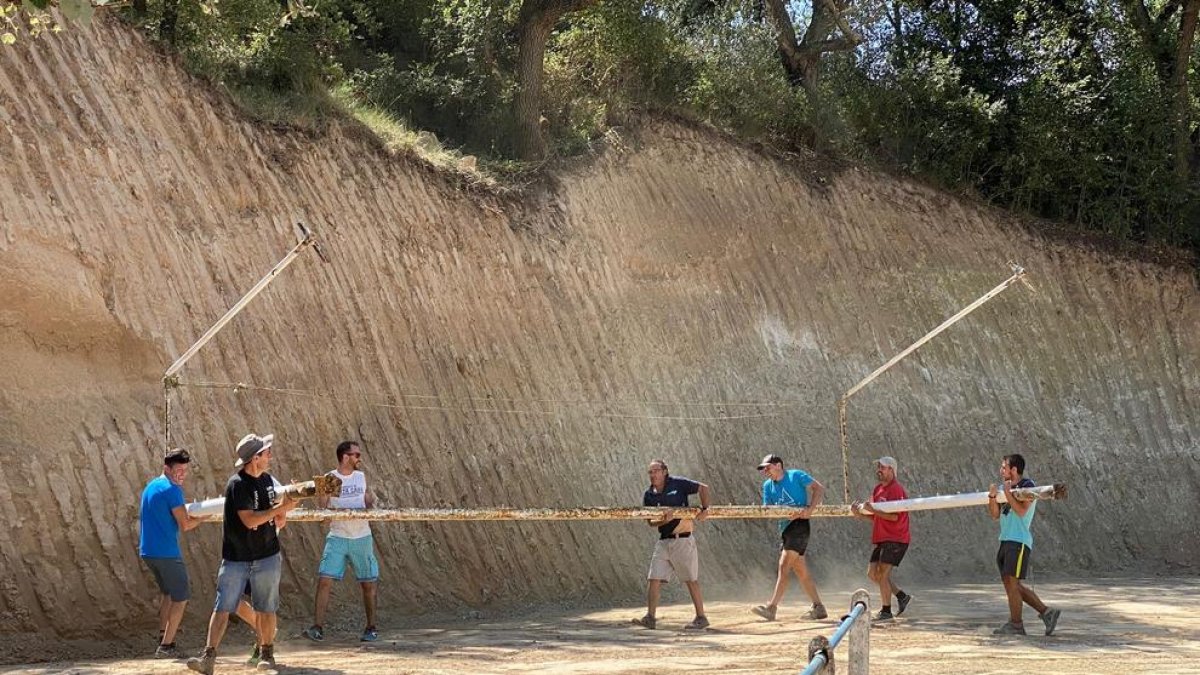 Membres del club i veïns del municipi traslladen una de les antigues porteries, que seran canviades.