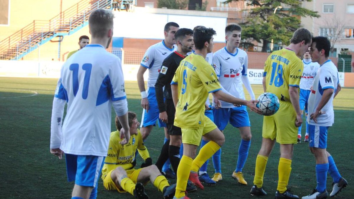 Els jugadors del Mollerussa i el Cambrils, en una acció polèmica després d’una falta, ahir durant el partit al Municipal de Mollerussa.