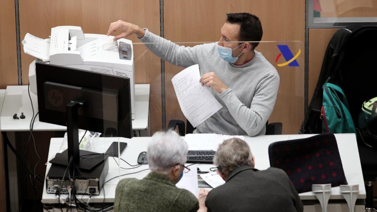 Un treballador de l’Agència Tributària atén una parella de contribuents.