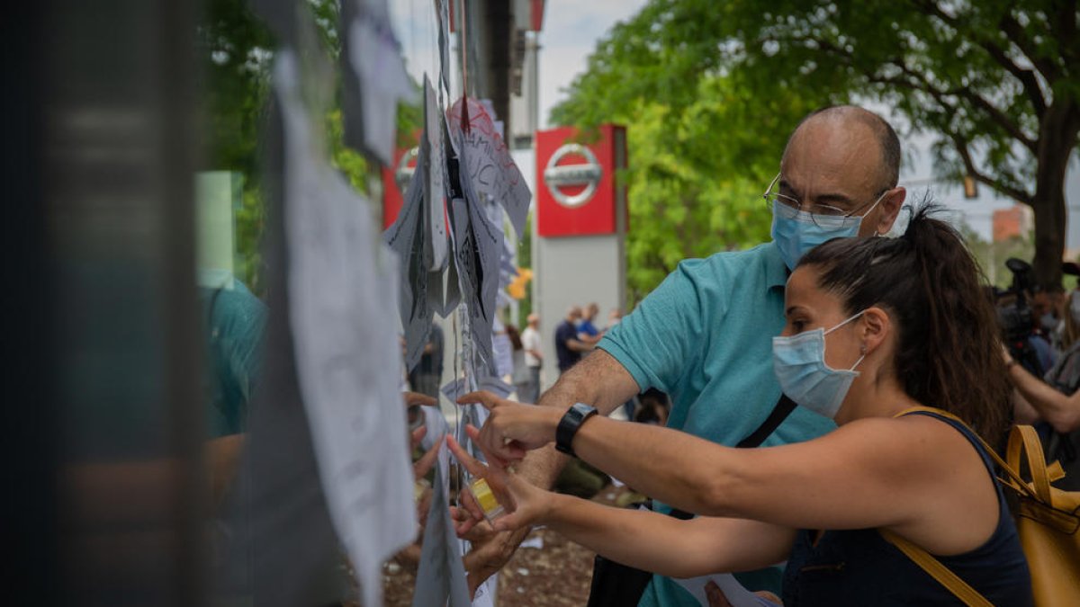 Treballadors de Nissan enganxen cartells com a protesta en un concessionari de la marca nipona.