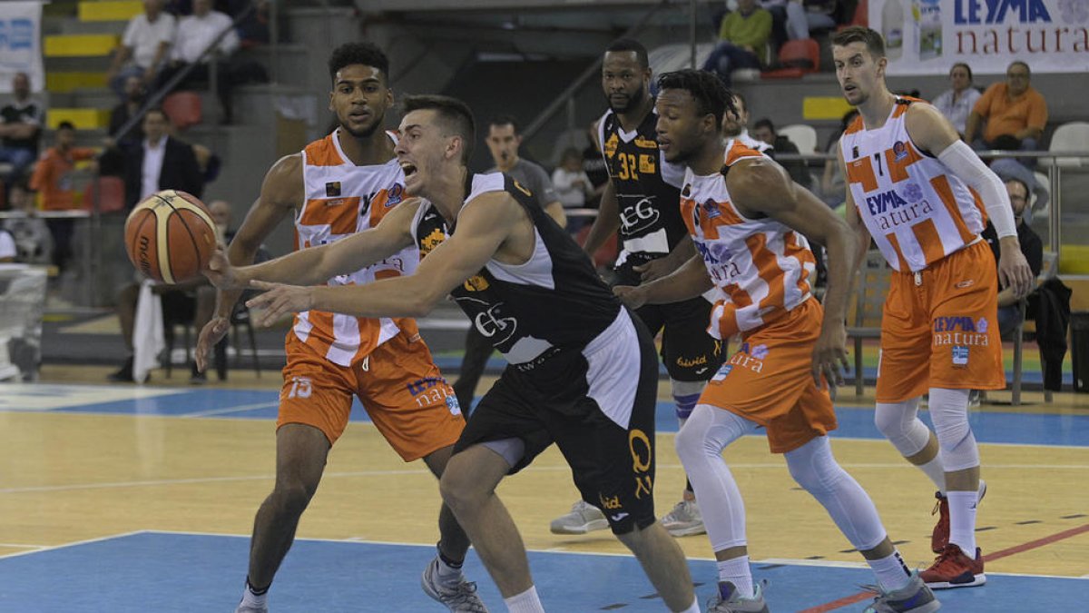 Adrián Chapela, que completó un gran partido en líneas generales, intenta un pase rodeado por varios jugadores del Coruña.