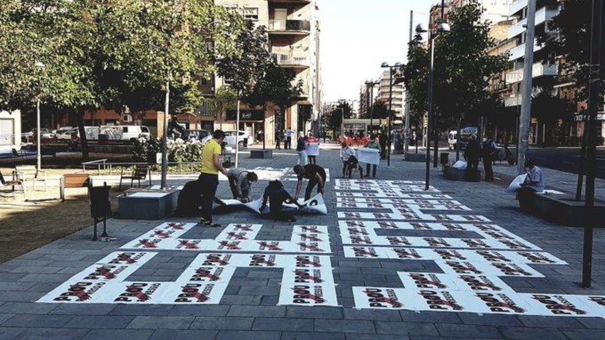 Activistas de Òmnium Lleida preparando el mosaico ayer por la mañana en la plaza Pau Casals.