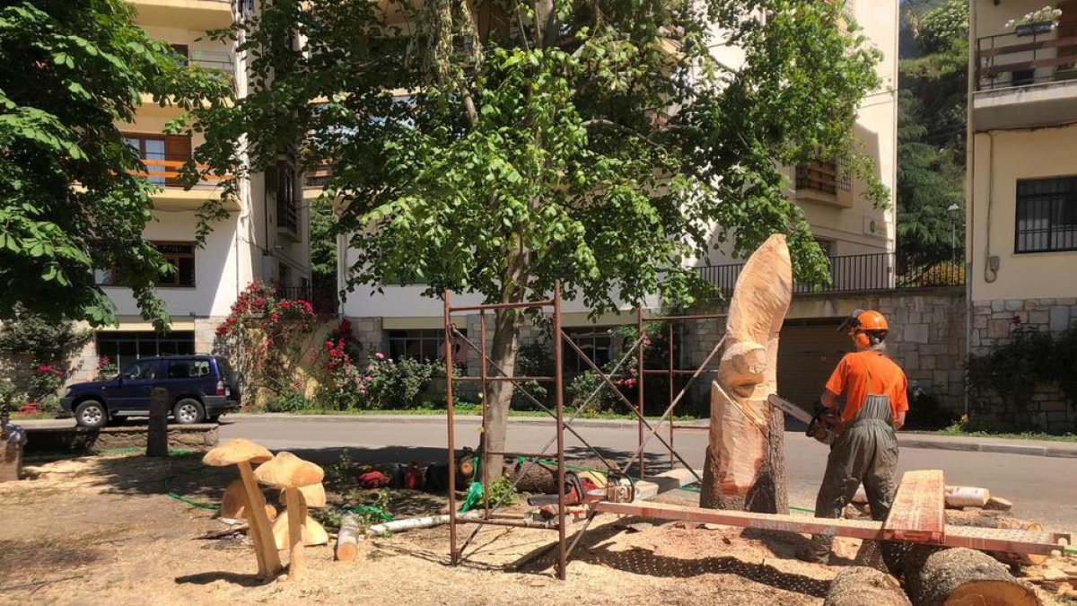 El escultor Roger Vidal trabajando uno de los árboles talados.