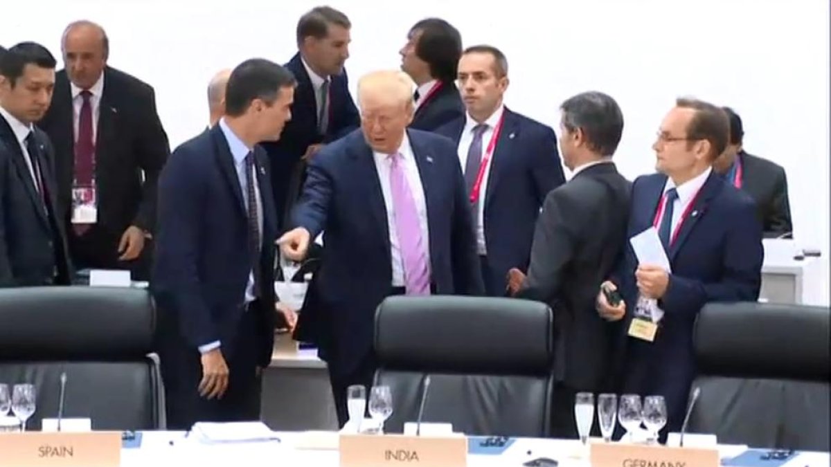 El momento en que Trump señala a Sánchez el lugar en el que debe sentarse en la mesa del plenario.