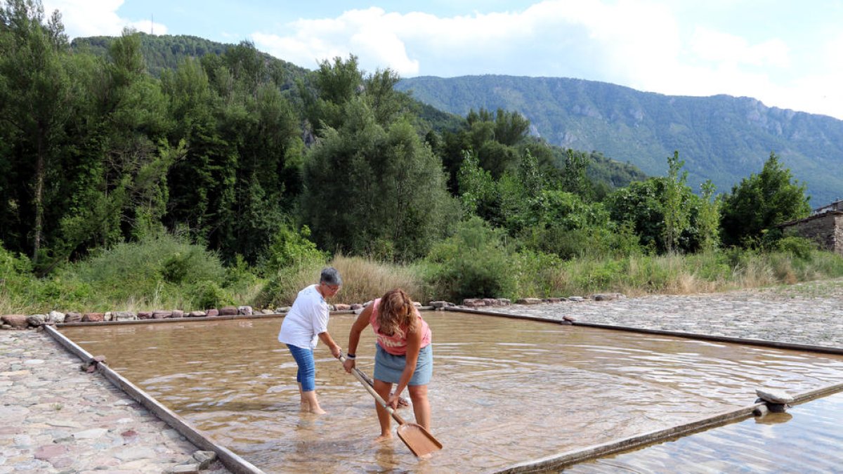 Dos persones treballant en una salina que encara funciona a Gerri de la Sal, al Pallars Sobirà.