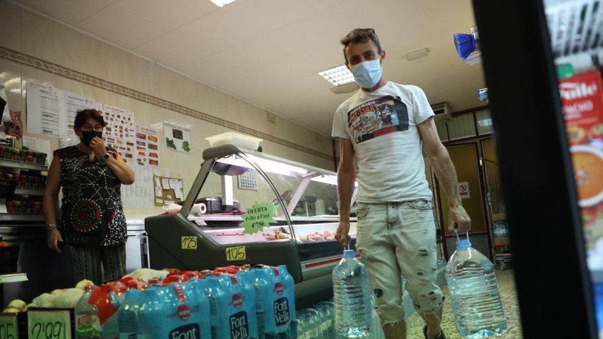 Un vecinos de Torres de Segre comprando garrafas para beber.