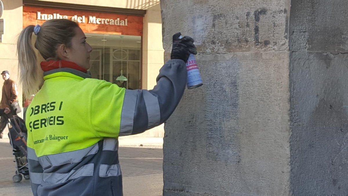 Imagen de la retirada de la pintura donde se podía leer ‘Franco’ en la plaza Mercadal de Balaguer.