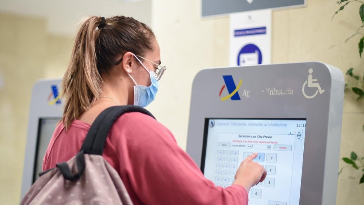 Una mujer gestiona su cita en una de las máquinas de la Agencia Tributaria.