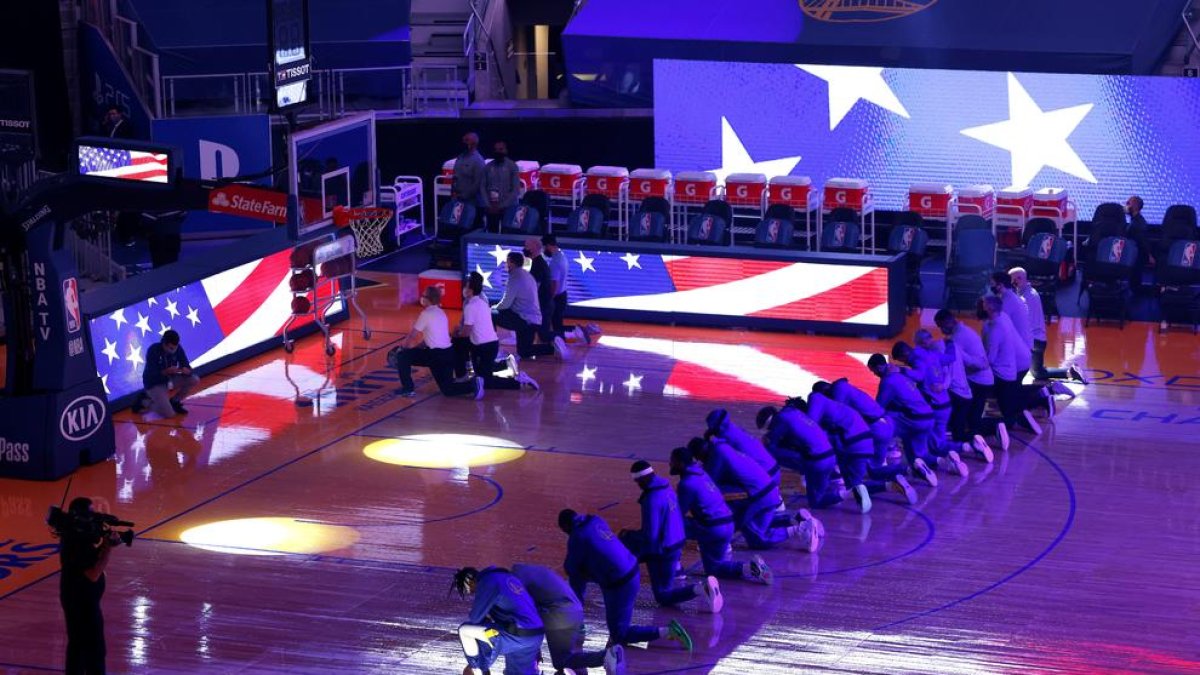 Jugadors agenollats abans del partit entre els Clippers i els Golden State Warriors.