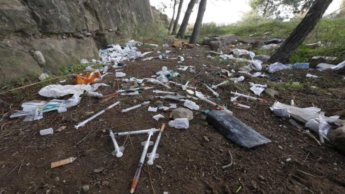 Decenas de jeringuillas usadas por toxicómanos, ayer en los aledaños del Turó.
