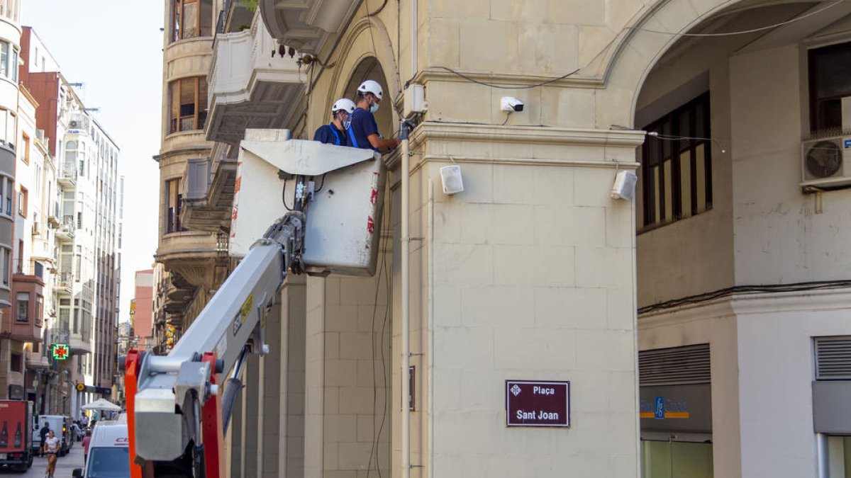 Dos operarios instalaron ayer una cámara en la plaza Sant Joan.