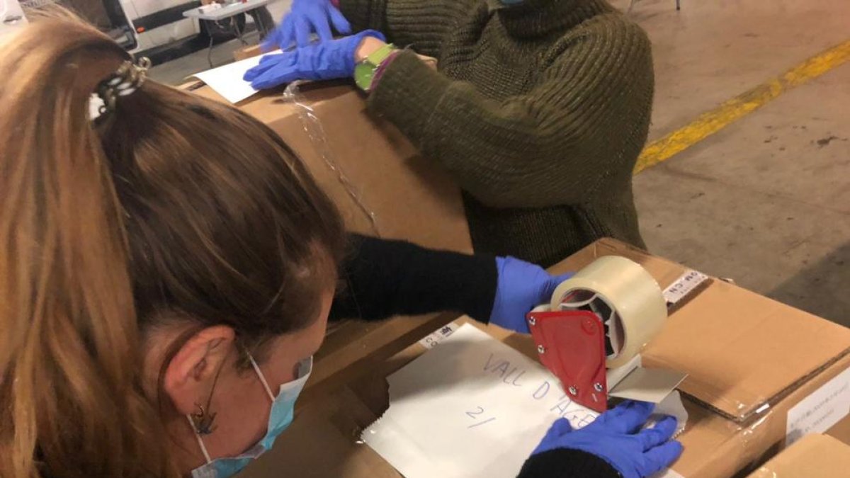 Una operària preparant productes sanitaris destinats a Àger, ahir, a l’aeroport del Prat.