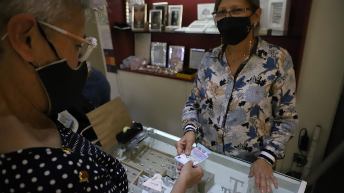 Una dona paga en efectiu a la joieria González, dilluns passat.