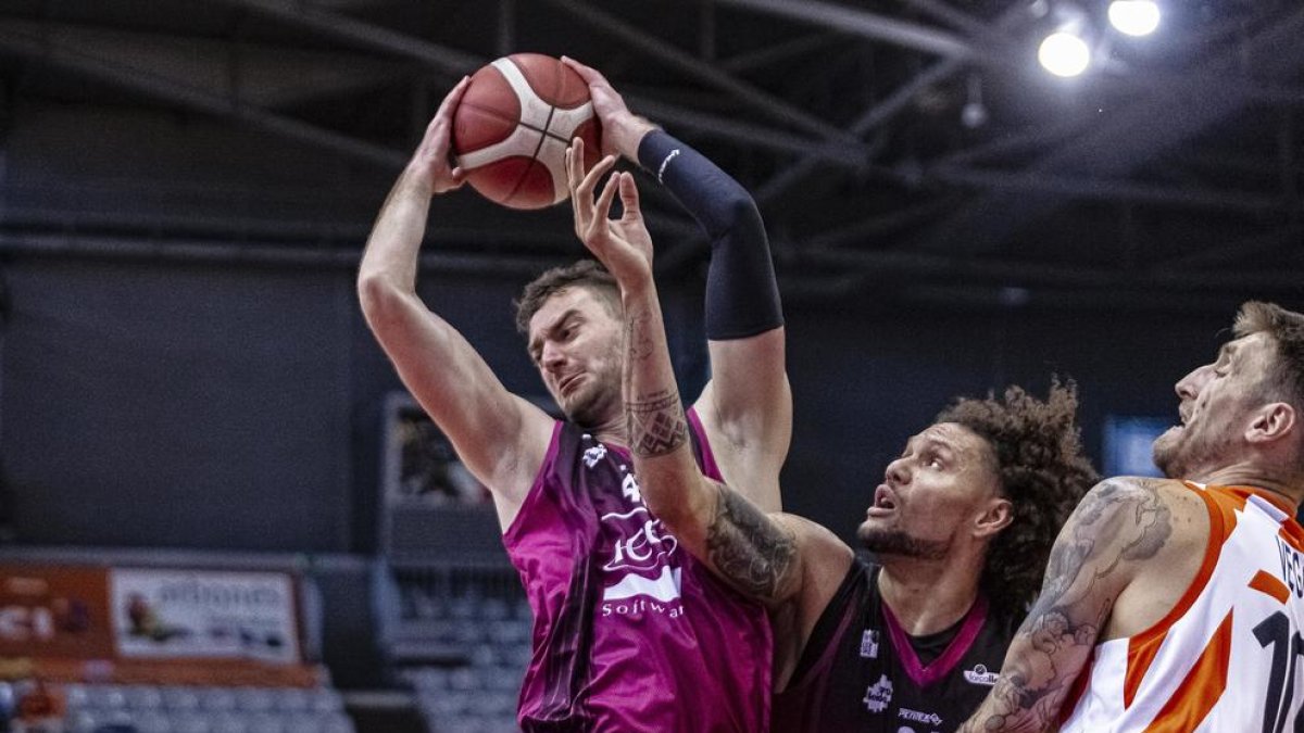 Matej Kavas i Michael Carrera, autor de la cistella de la victòria, disputen un rebot.