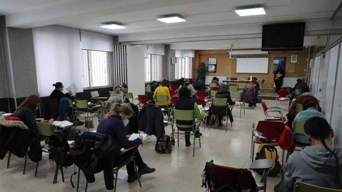 Diversos aspirants fent l’examen en una aula de l’institut Josep Lladonosa.