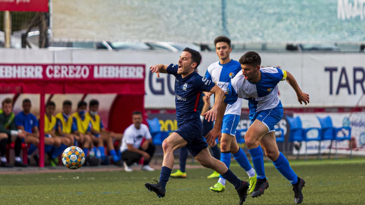 Roger Canadell fa un gest de dolor perseguit per un rival.