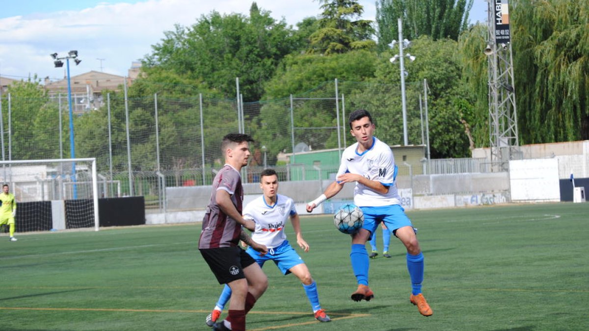 Un jugador del Mollerussa intenta controlar una pilota alta davant d’un rival del Júpiter.