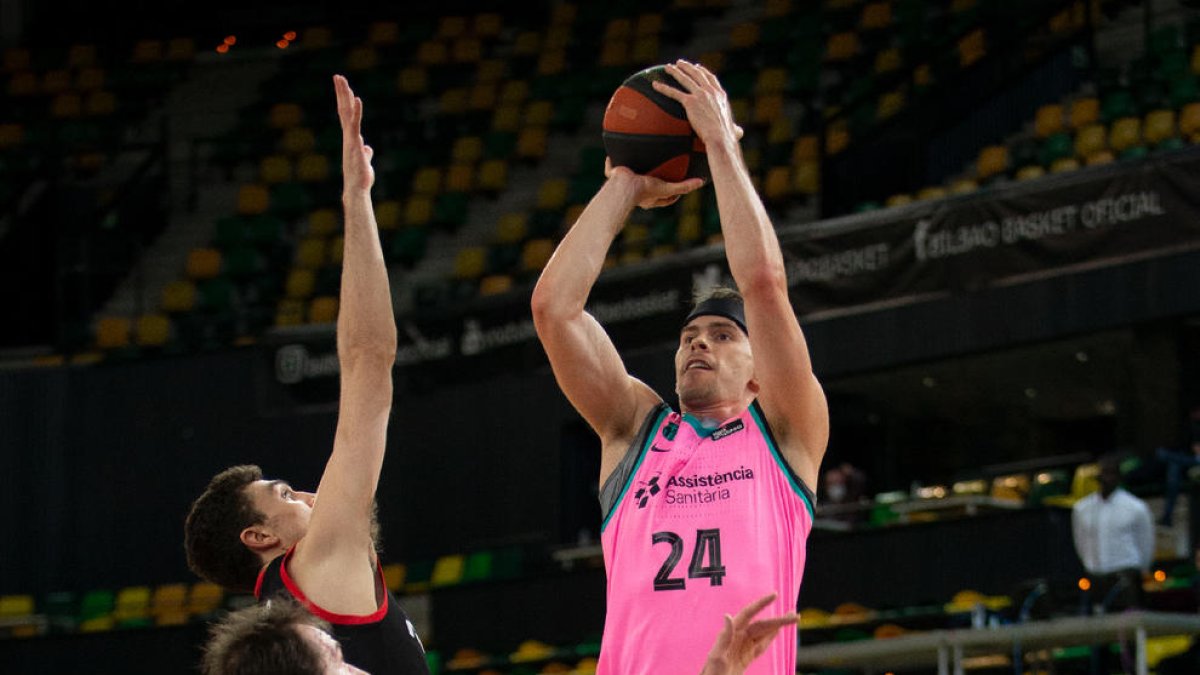 Kuric llança a cistella davant l’oposició de dos jugadors del Bilbao.