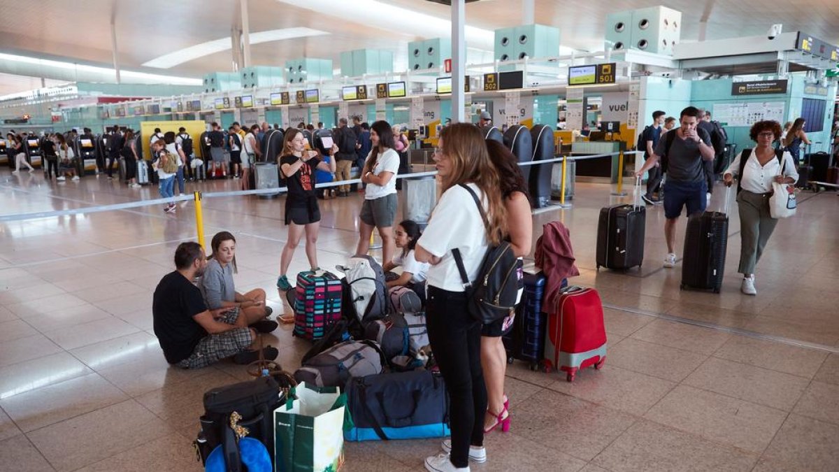 Diversos passatgers esperant ahir davant els taulells de Vueling a l’aeroport del Prat.
