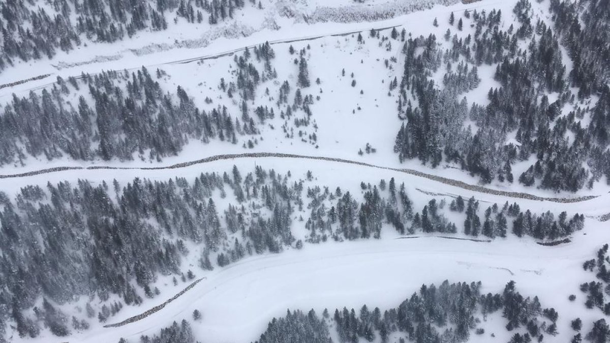 Vista aèria dels revolts del port de la Bonaigua coberts de neu (esquerra). A la imatge dreta, esquiadors a les pistes de Port Ainé.