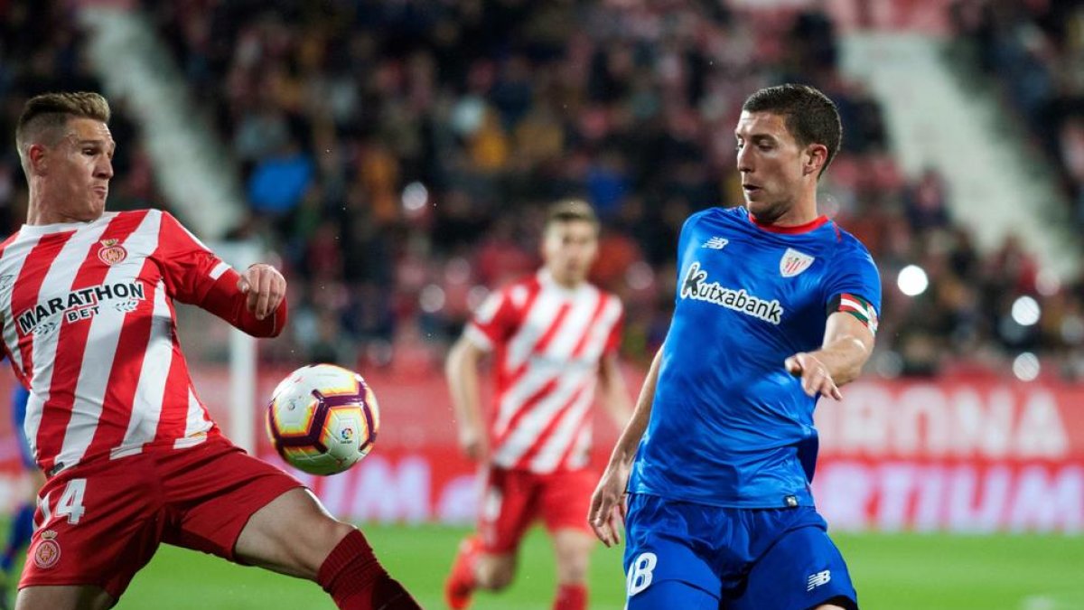 Oscar de Marcos disputa una pilota al gironí Raúl Carnero, ahir a Montilivi.