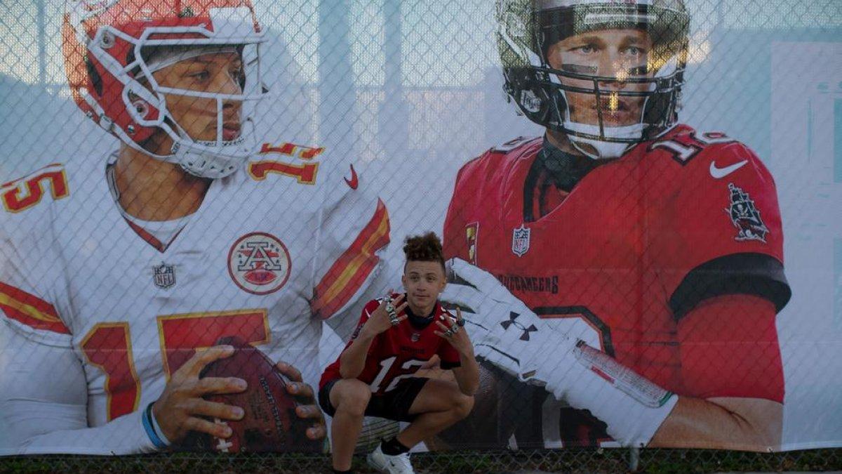 Un aficionado, junto al cartel promocional de la Super Bowl.