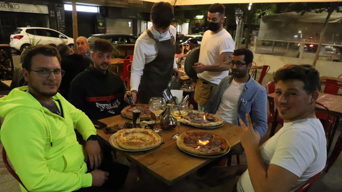 Un grupo de amigos cenando al aire libre en un restaurante del centro de Lleida ciudad.