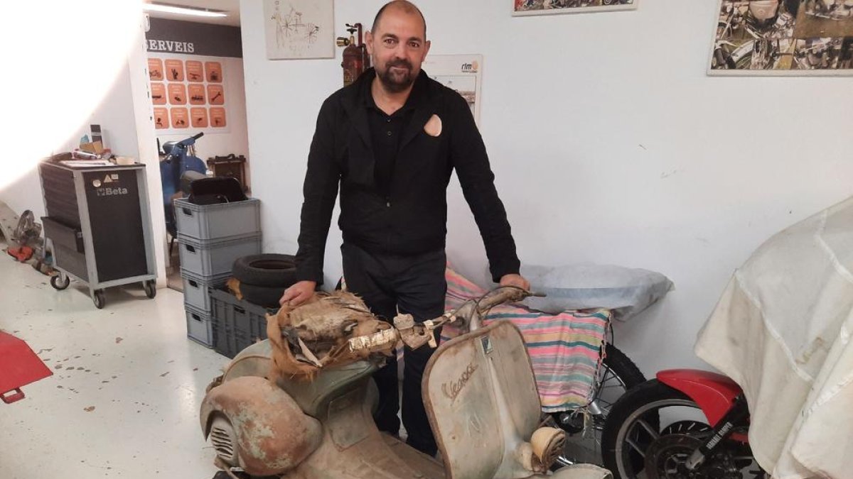 Rafael Roig, propietari del taller, amb una Vespa a restaurar.