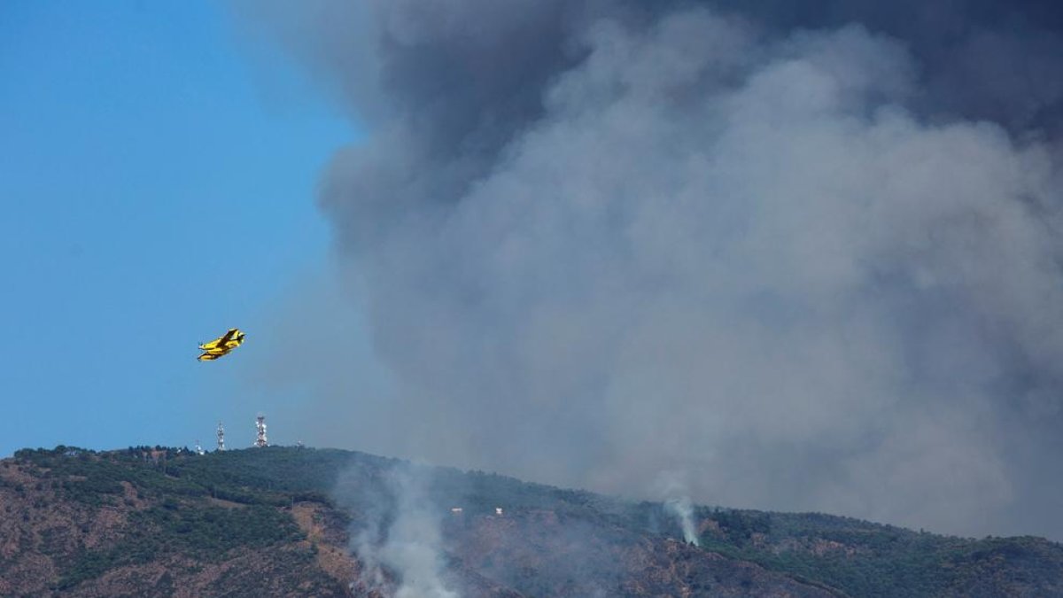 Un hidroavió sobrevola la zona cremada a Sierra Bermeja.