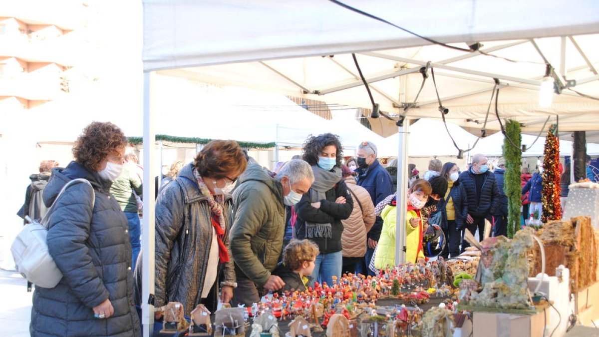 Varias personas miran los adornos expuestos en una de las paradas.