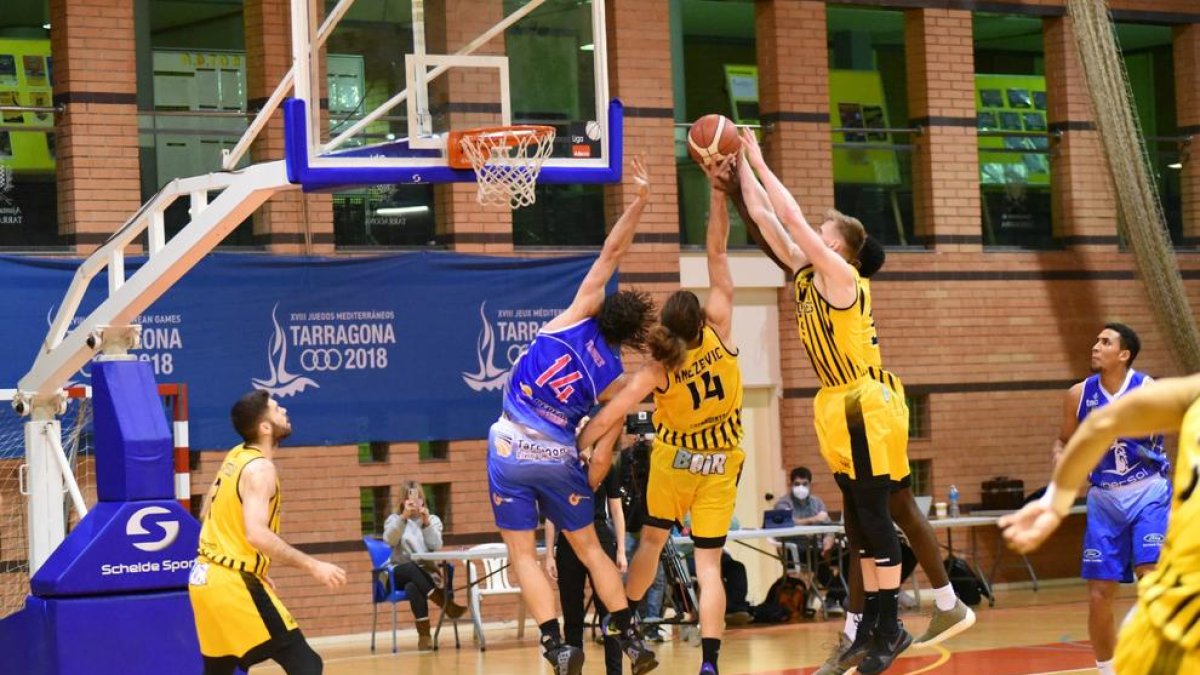 Mads Stürup i Filip Knezevic lluiten per un rebot amb el Ferran Torres, històric del Tarragona.